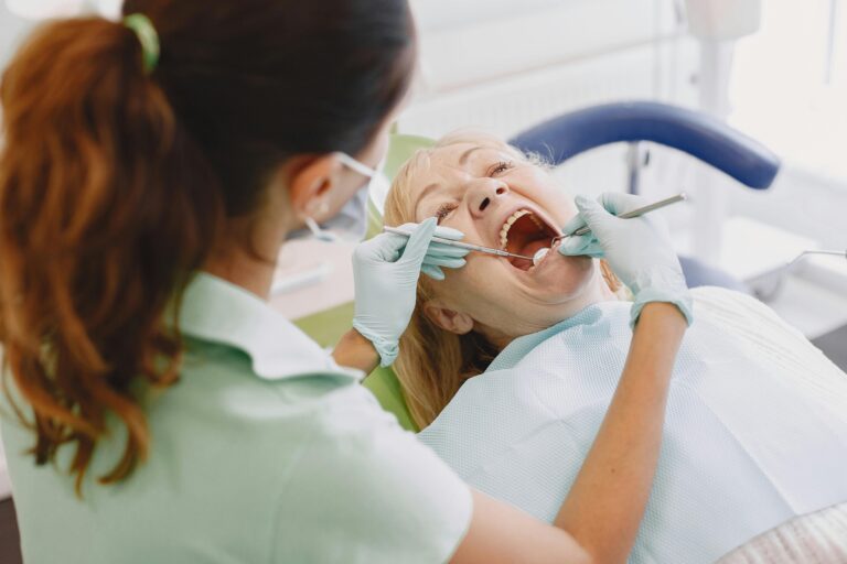 A female dentist examines a patient in a dental clinic, showcasing professional care.