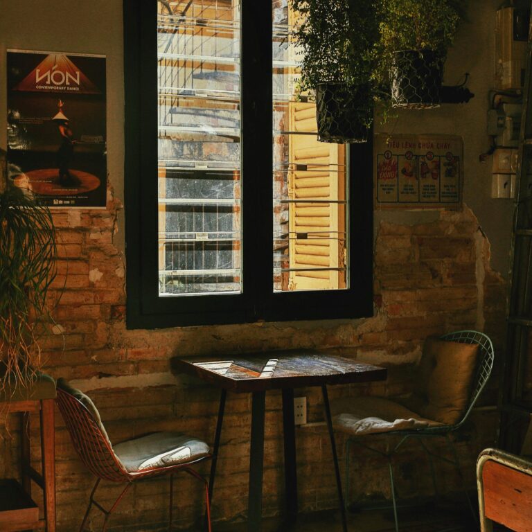 Charming vintage-style room with natural light, indoor plants, and cozy seating.